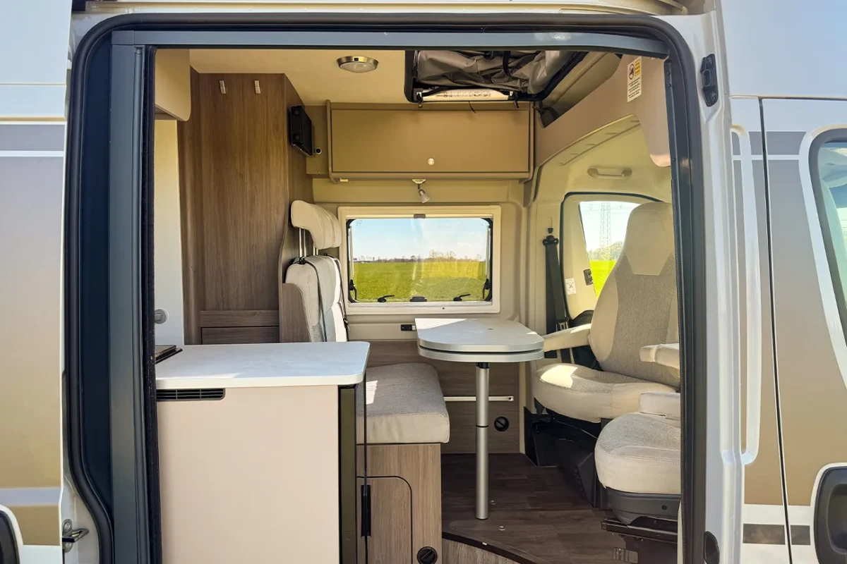 Blick durch die Seitentür in den Innenraum des Fiat Carado Campers mit einladender Sitzgruppe