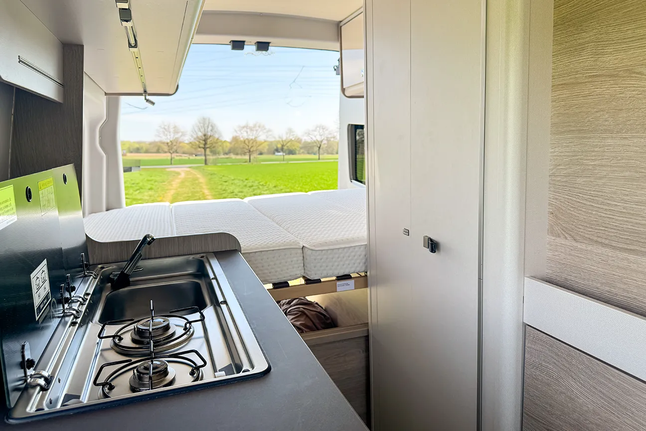 Küchenzeile und Blick durch die geöffnete Hecktür des Bürstner Lineo 600 Campers bei Autohaus Hempel in Braunschweig