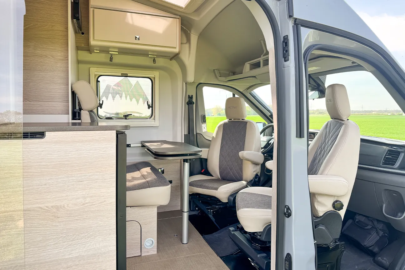 Blick durch die geöffnete Seitentür auf die einladende Sitzgruppe des Bürstner Lineo 600 Campers bei Autohaus Hempel in Braunschweig