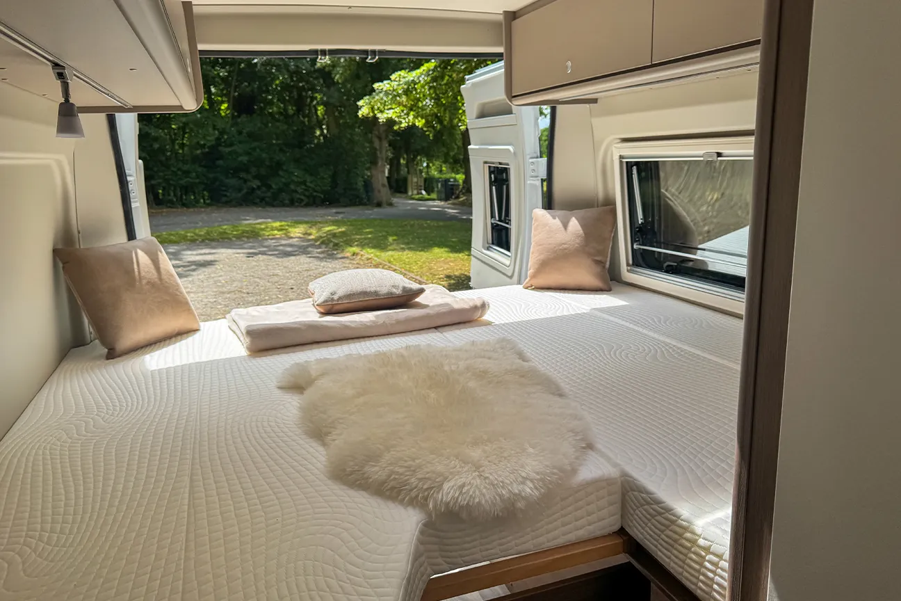 Innenraum mit Längsbetten des Fiat Carado 640 Campers mit geöffneter Seiten- und Hecktür