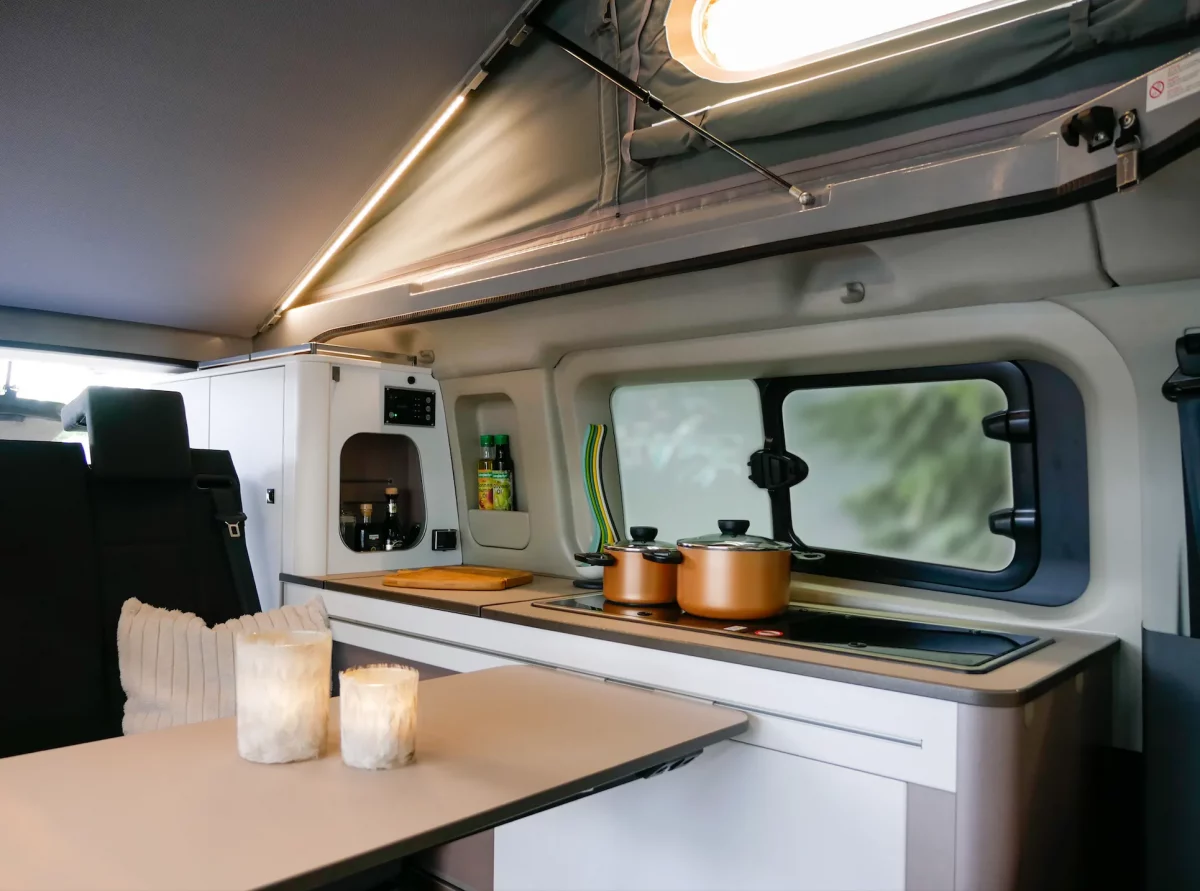 Der Innenraum des Ford Camper Copa mit praktischer Sitzgruppe für bis zu 4 Personen und Küchenzeile bei Autohaus Hempel in Braunschweig.